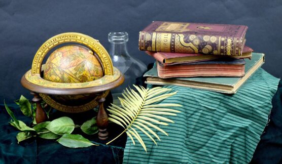 Still life of a gilt 18th century edition of Virgil's Aeneid with an antique globe.