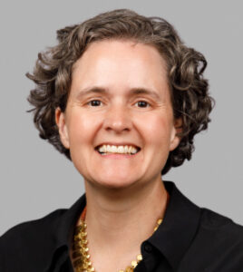 Headshot of a smiling woman in a black shirt.