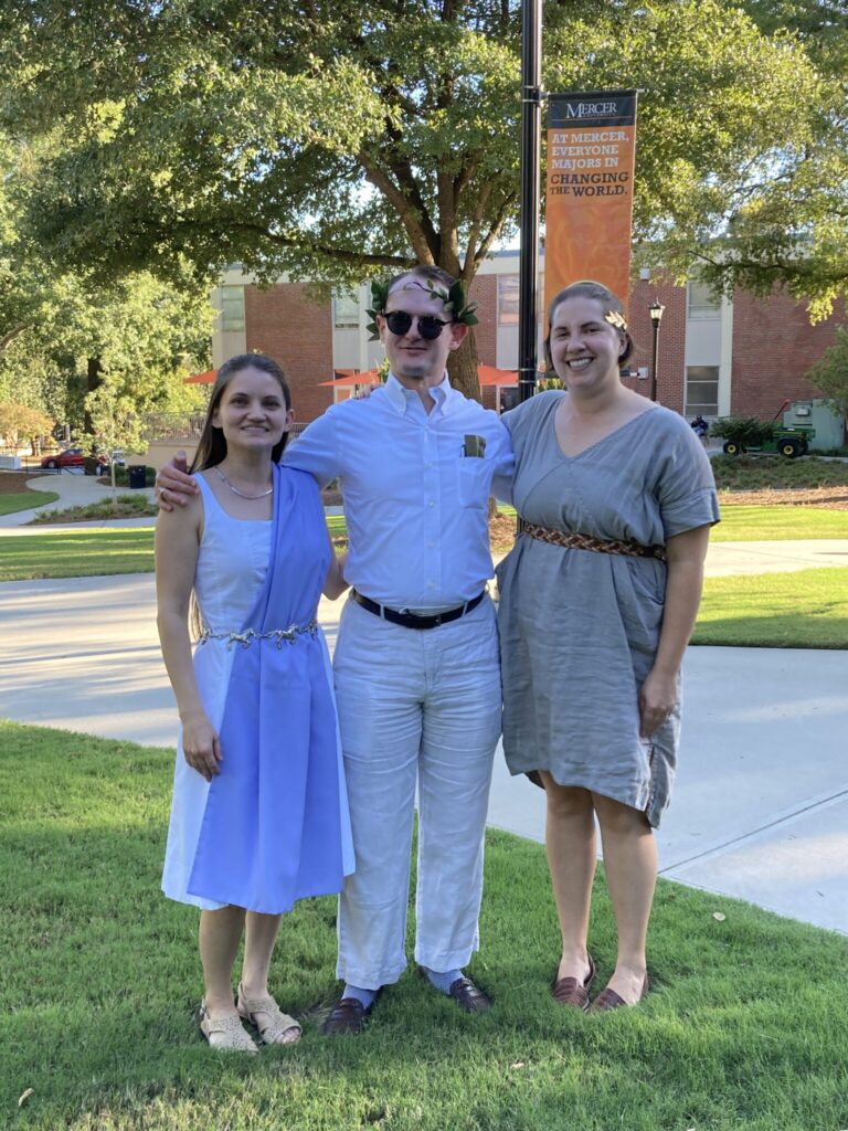 Three faculty standing on grass