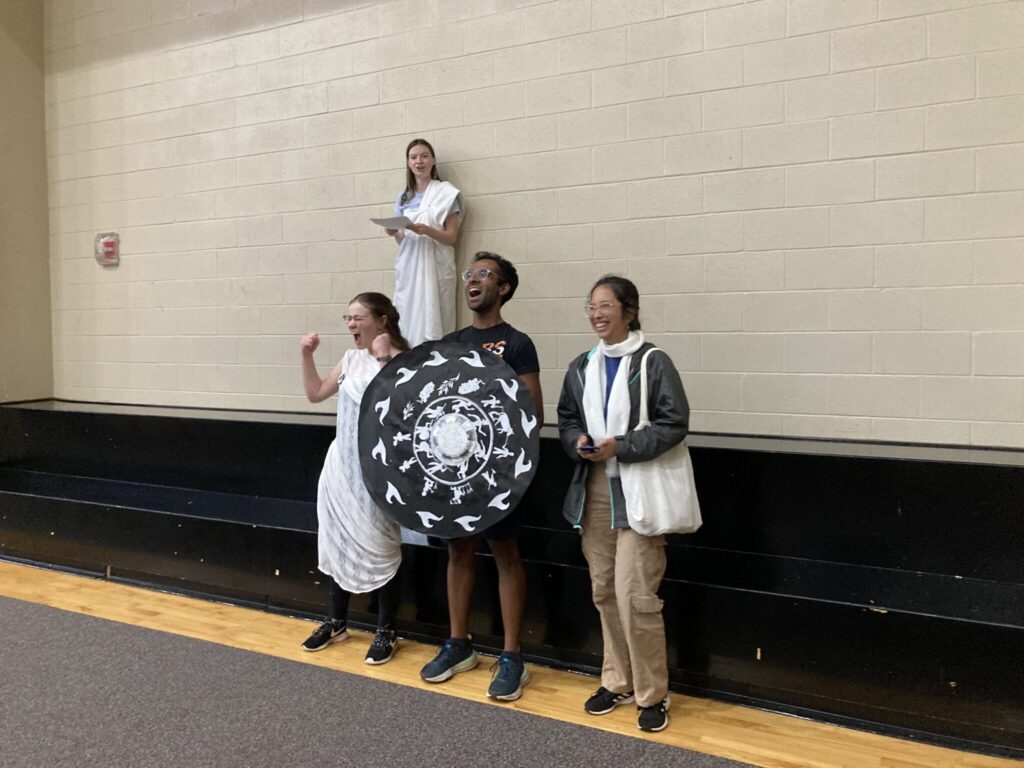 Four students in Greek costume performing